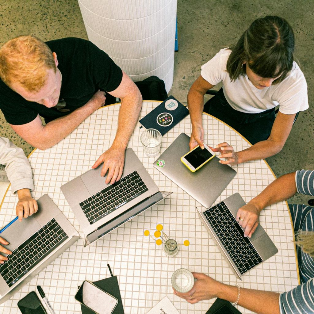 Four People Using Laptop Computers and Smartphone