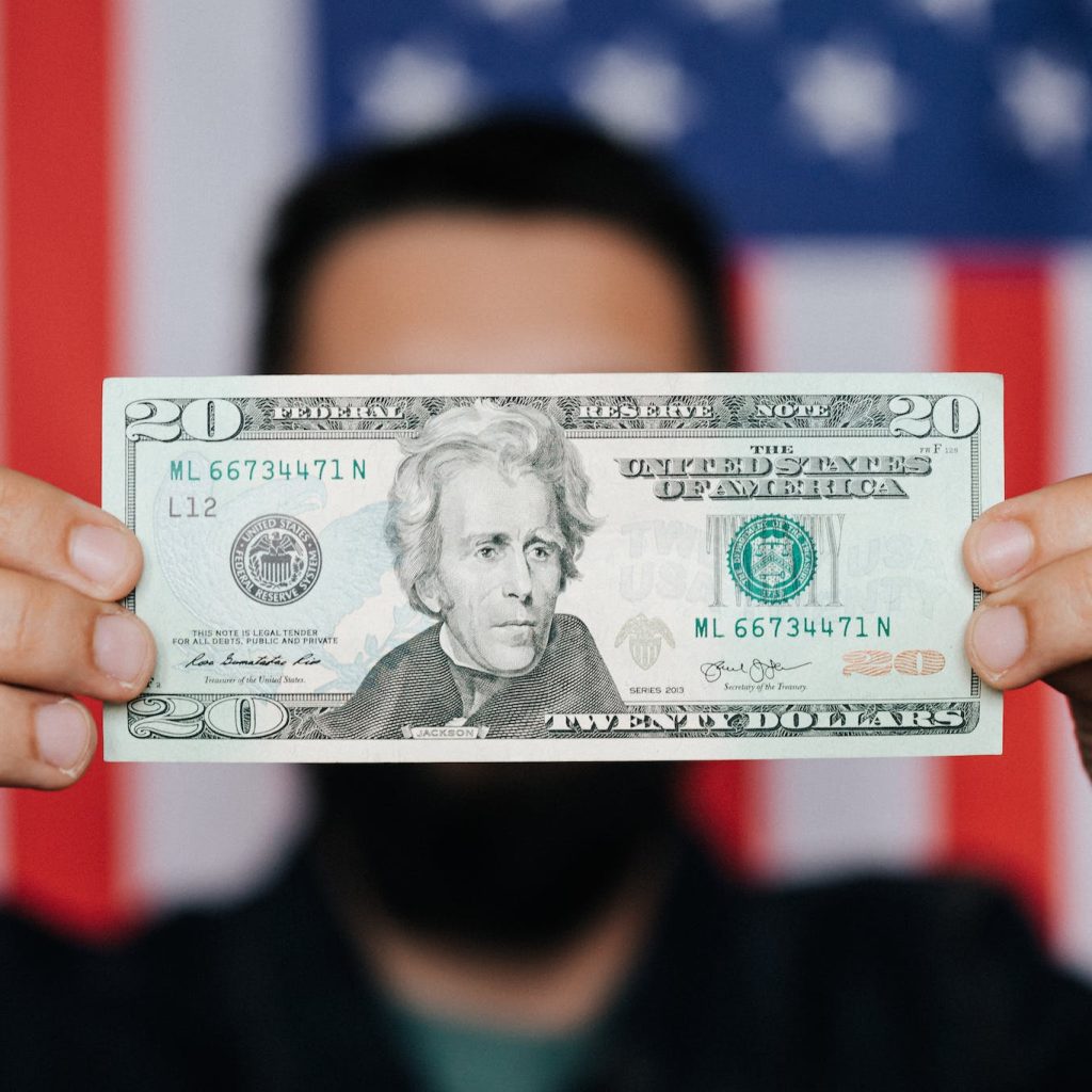 Unrecognizable man showing 20 American dollars