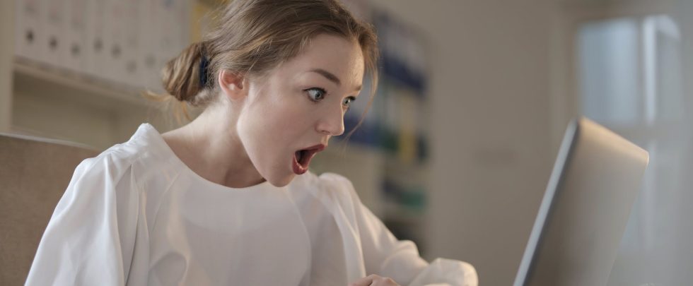 Woman in White Long Sleeve Shirt Using Silver Laptop Computer